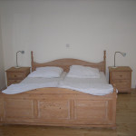 Schlafzimmer mit Holzfußboden und gewachstem Pinienbett